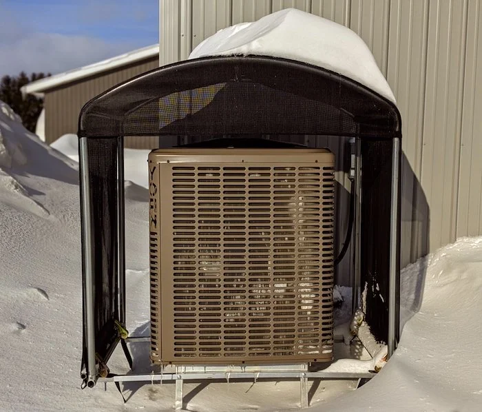 Thermopompe avec protection hivernale installée pendant une chute de neige